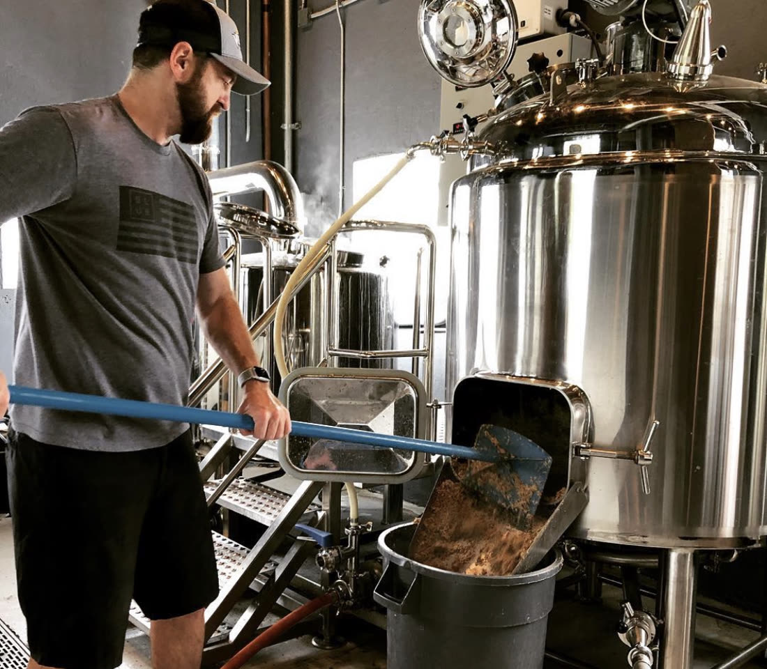 Distiller working at the stainless mash tun